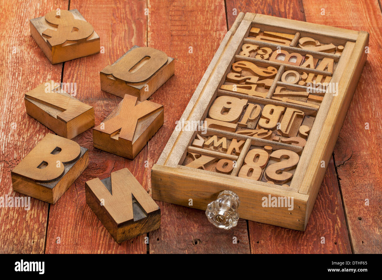 letterpress wood type blocks in a typesetter drawer against rustic red