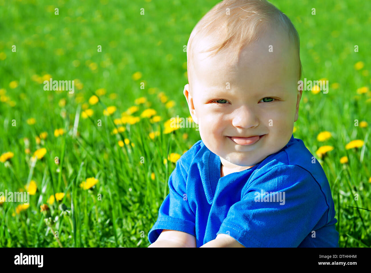 the beautiful small child the boy plays on a green meadow Stock Photo