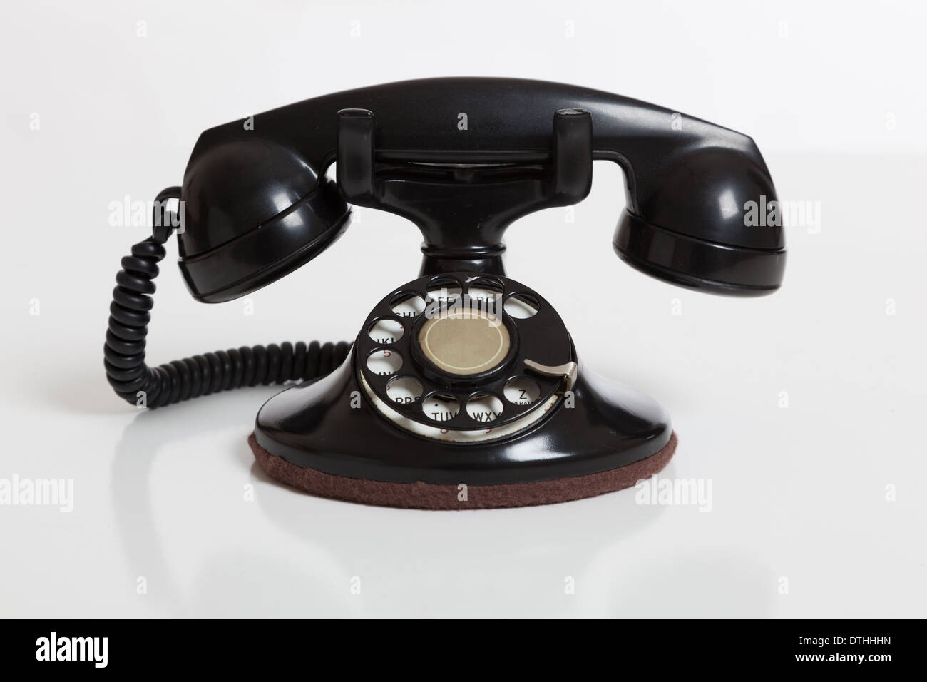 A black, vintage rotary phone on a white background Stock Photo