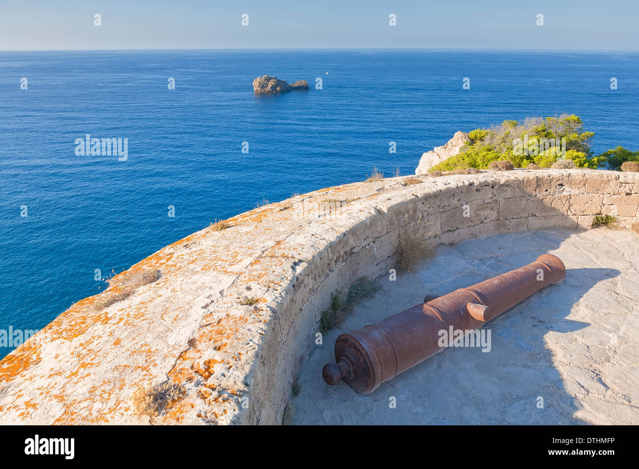18th century Torre d'Albarca pirate watchtower and cannon facing Minorca strait. Artà area. Majorca, Balearic islands, Spain Stock Photo