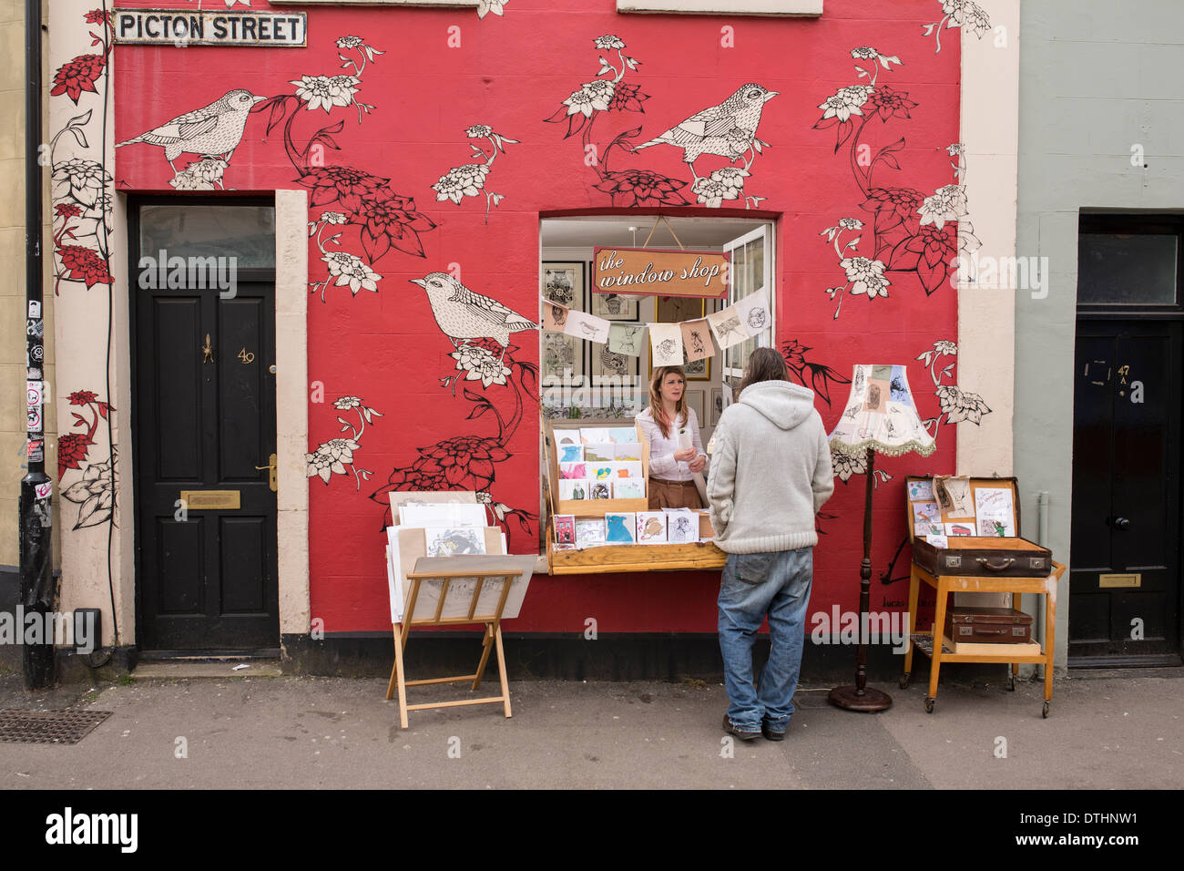 Illustrator designer with pop up shop out of her front window in