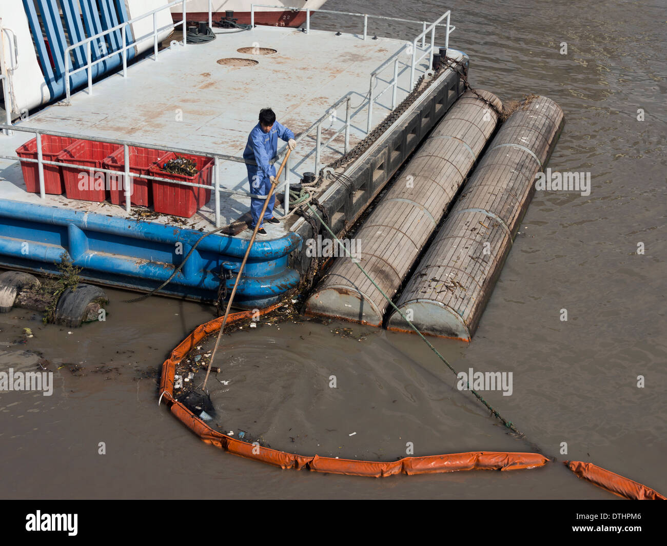 Worker cleaning up debris from the Huangpu River, Shanghai, China Stock Photo