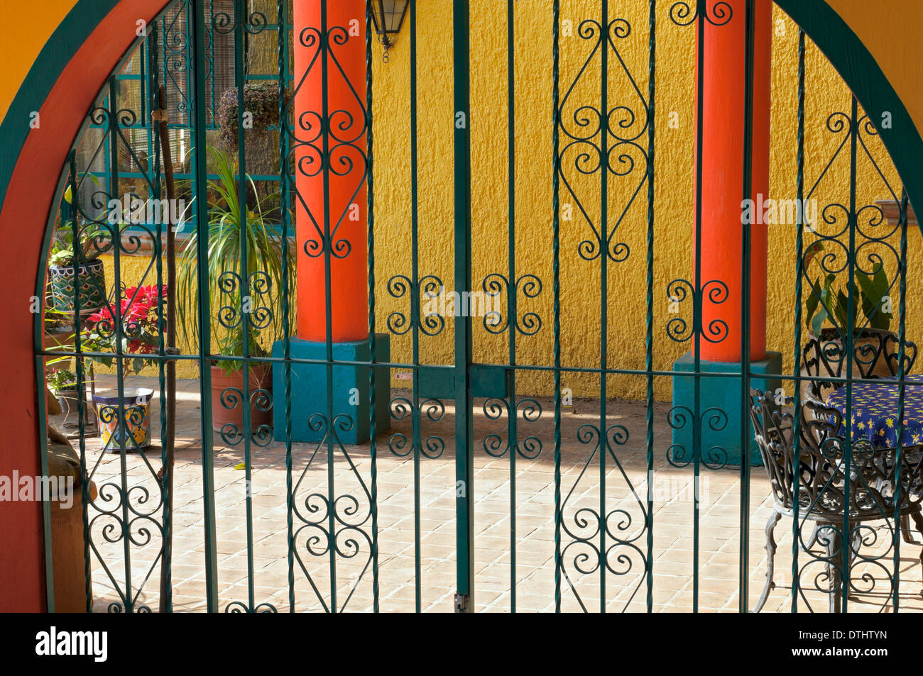 Colorful patio and home behind a gated archway Stock Photo