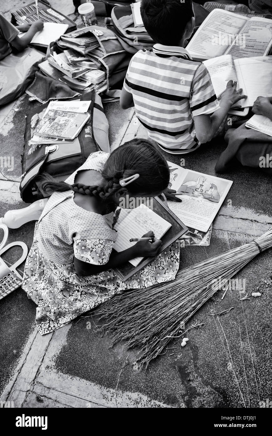 Indian children doing school work outside a rural Indian village house. Andhra Pradesh, India Stock Photo