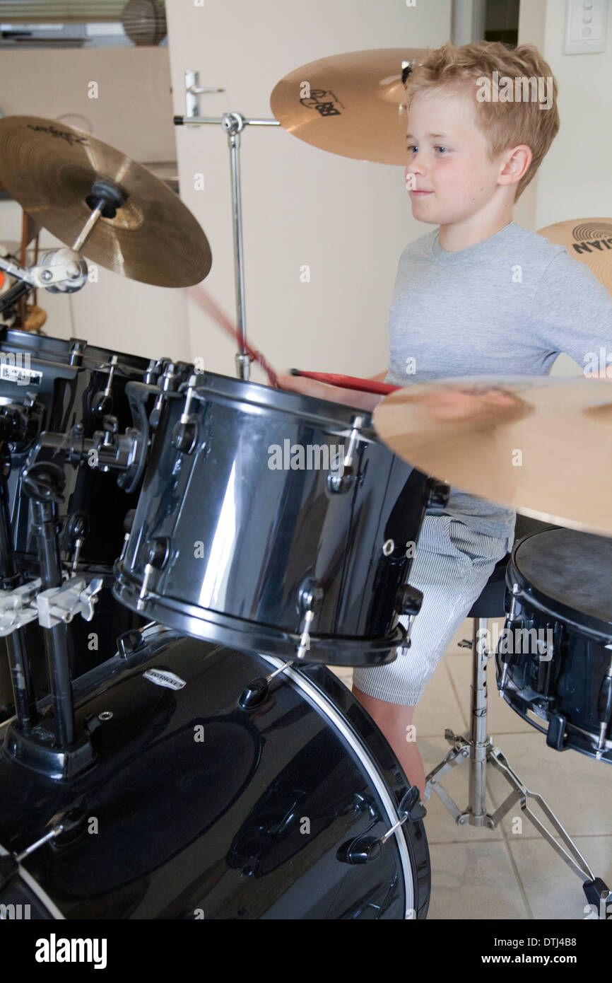 Boy Playing Drums at Home Stock Photo