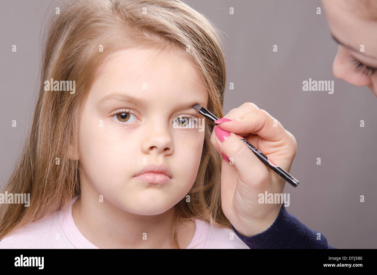 Makeup artist in the process of makeup brings eyebrows on the face five
