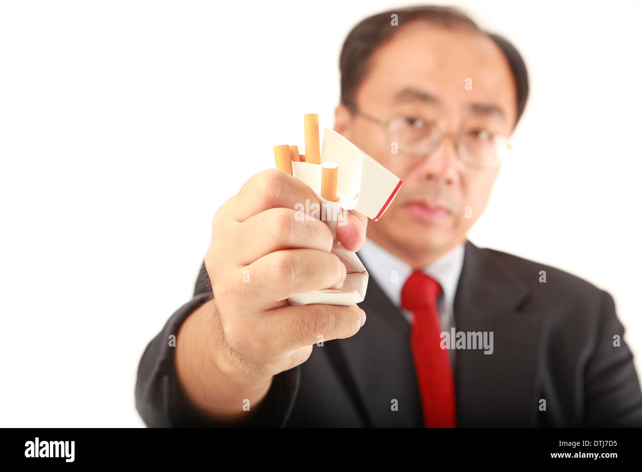 Asian man with a pack of cigarettes indicating quit Stock Photo