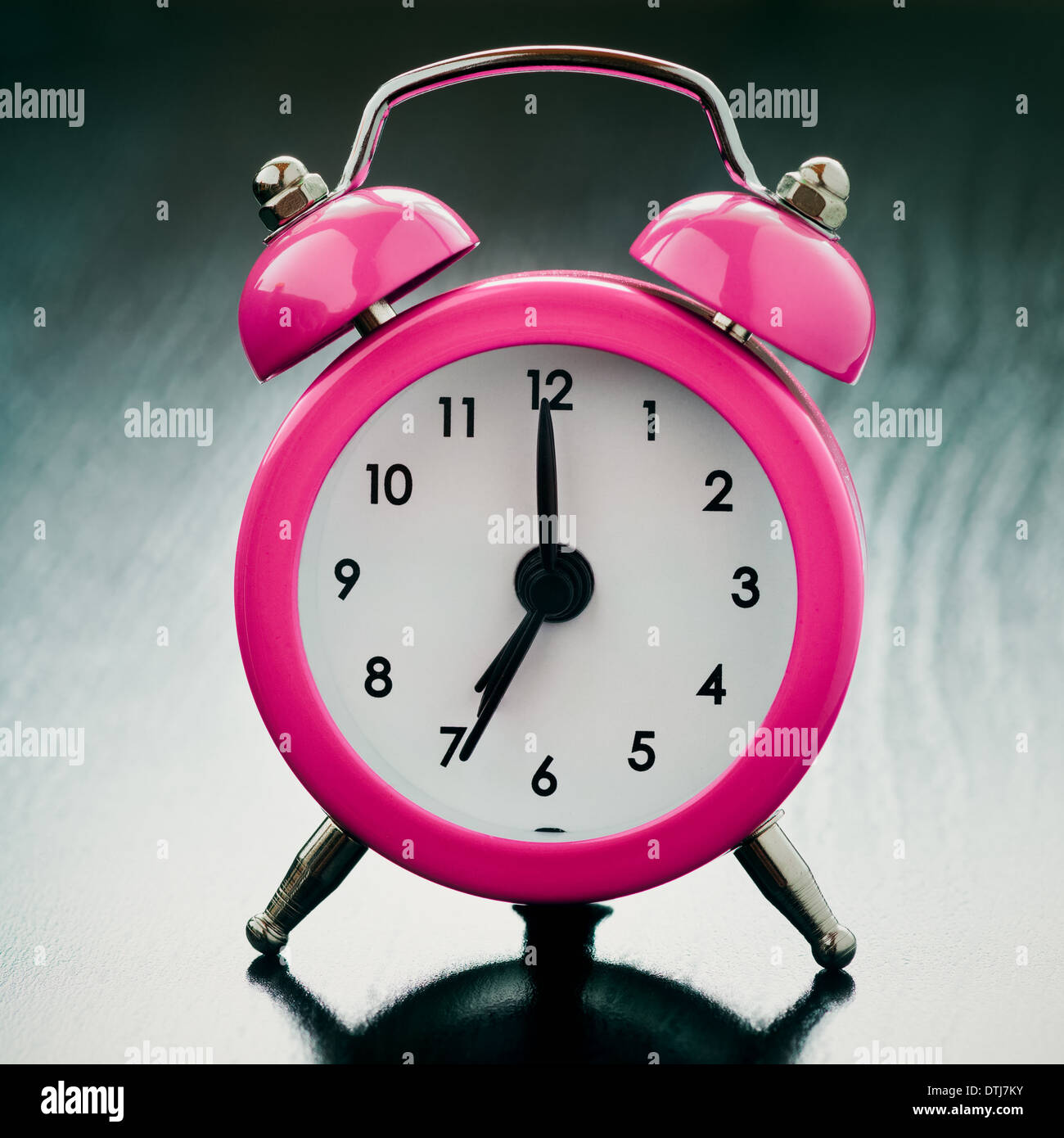pink Alarm clock close up on bedside table Stock Photo