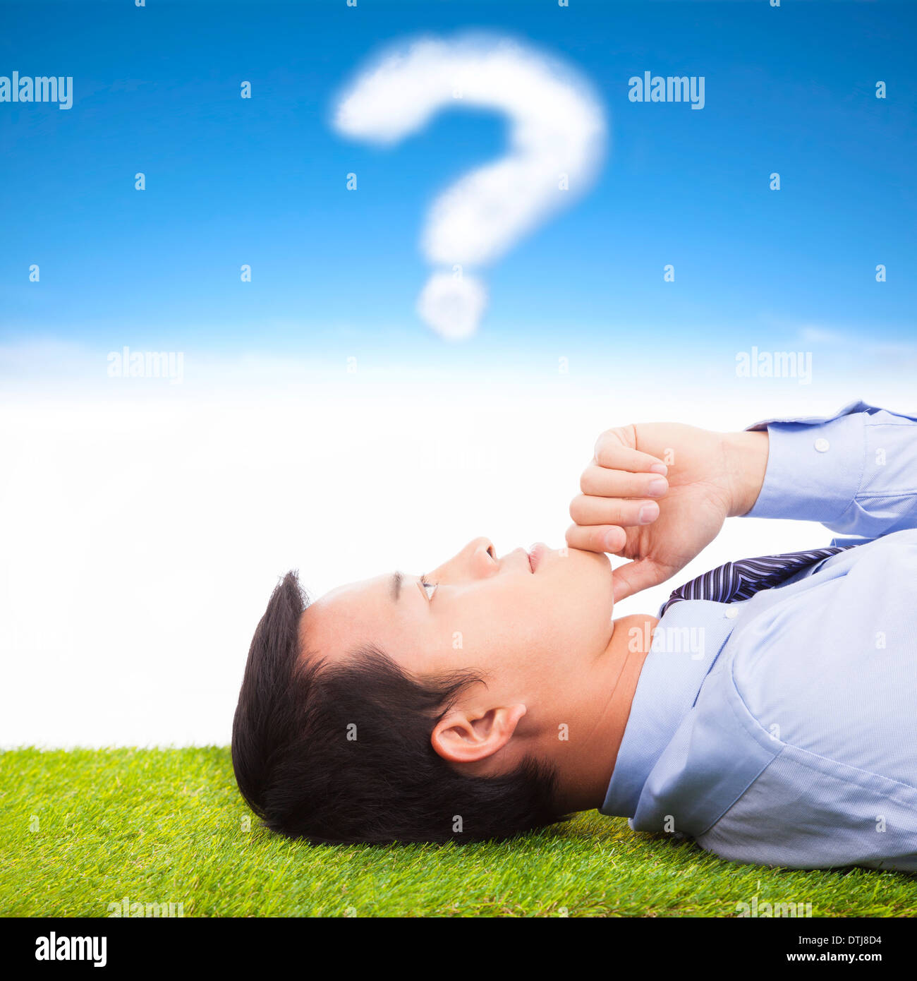 young businessman thinking with  query symbol on a meadow Stock Photo