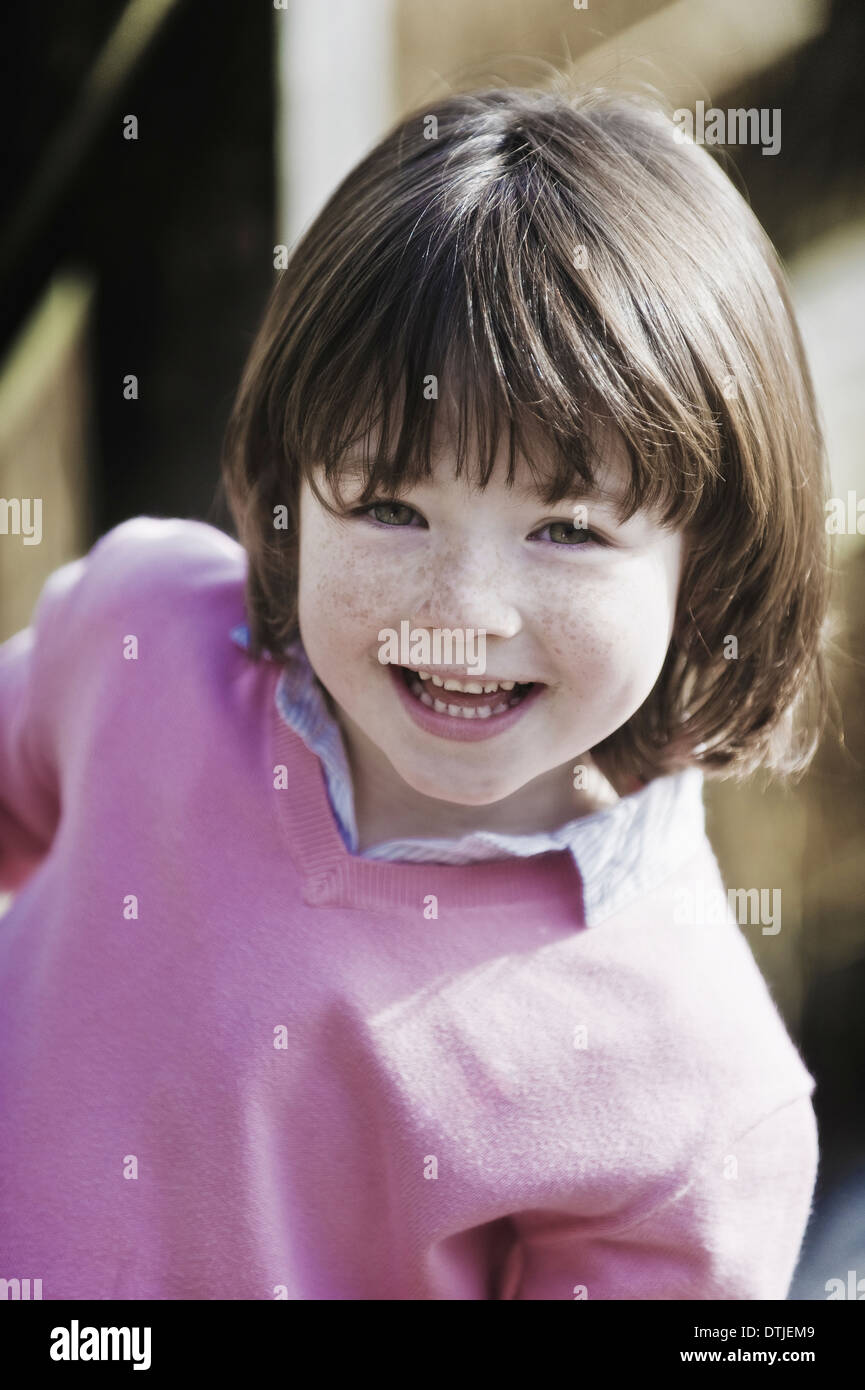 Young boy with brown hair and freckles wearing pink sweater England