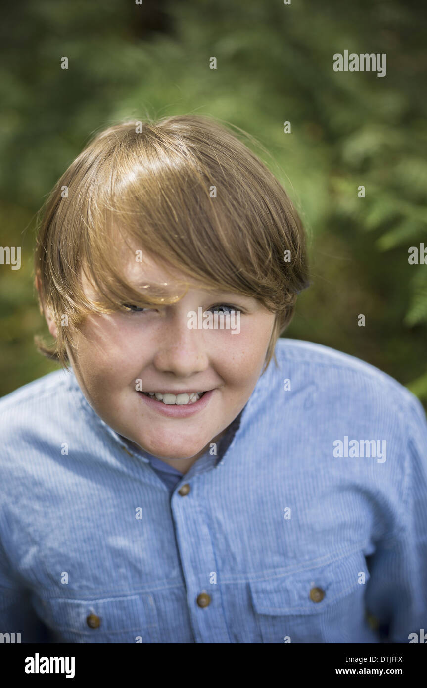 A boy in a denim button down shirt looking up at the camera  Hampshire England Stock Photo