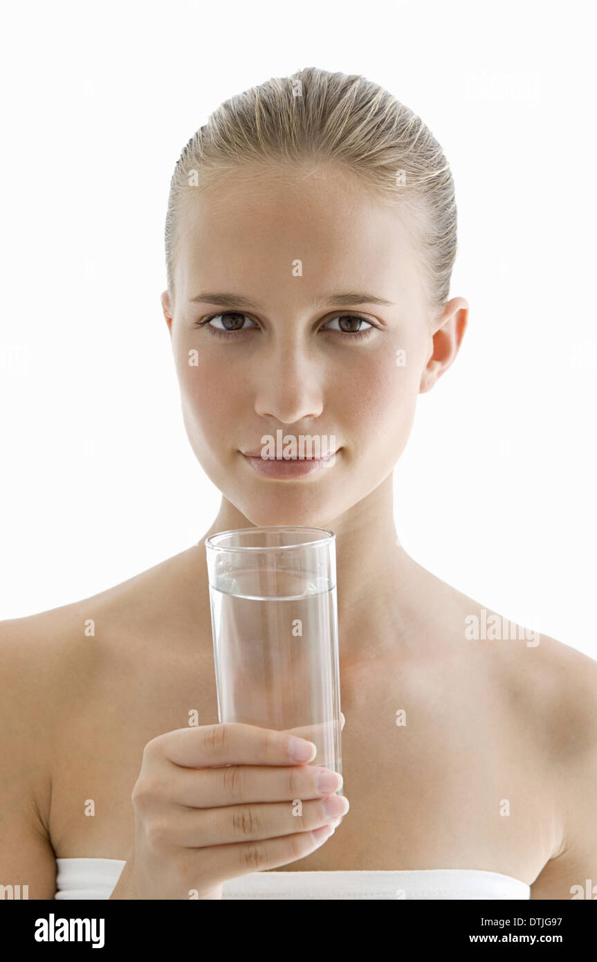 A spa treatment centre A young woman drinking a glass of water for