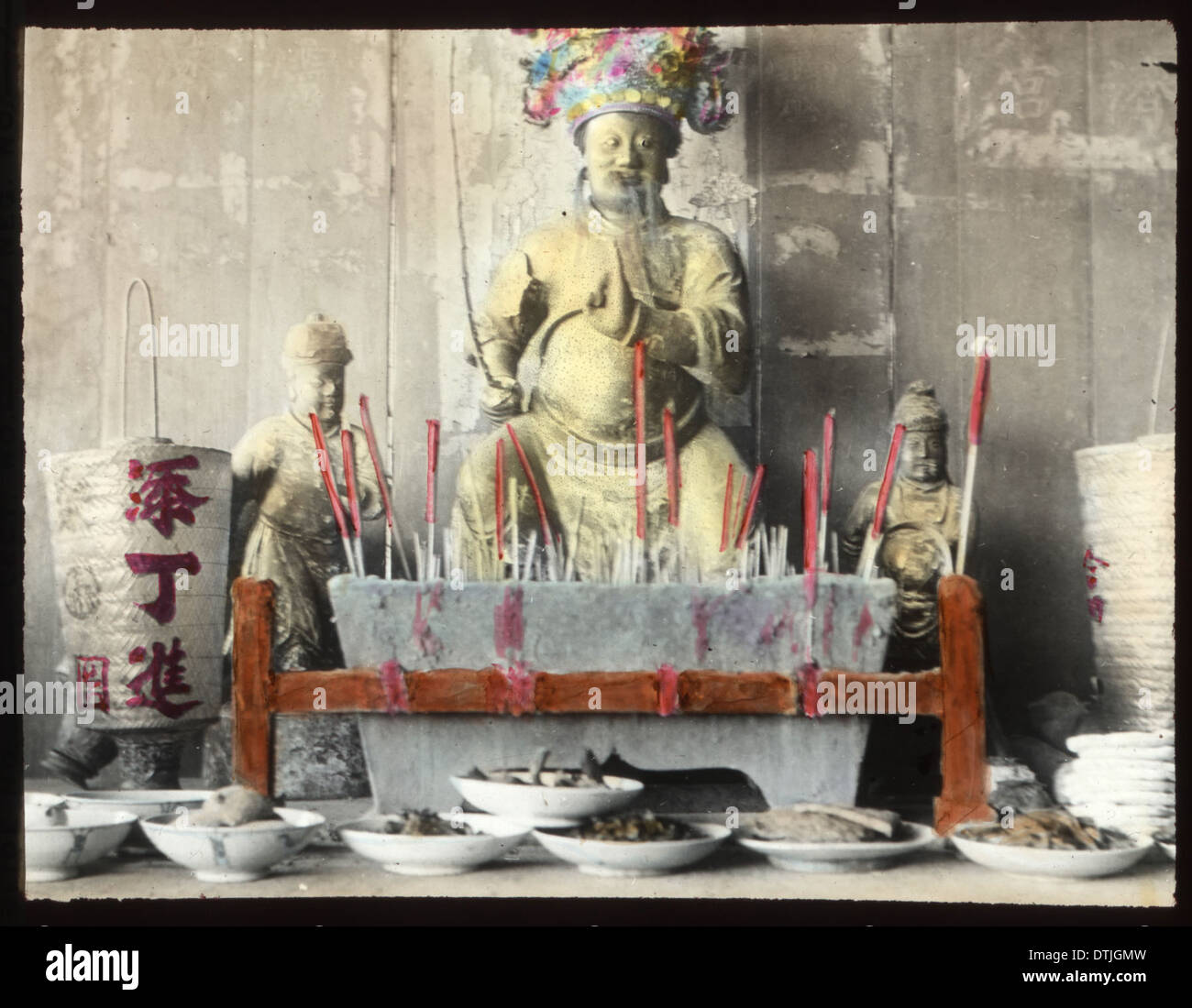 An incense offering being made to a religious statue in China, captured ...