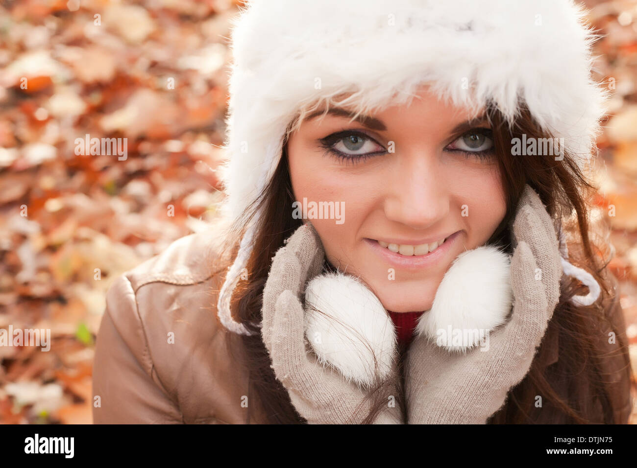 Happy brunette is having a nice time in the park while it's autumn Stock Photo