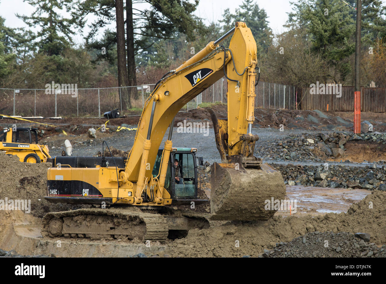 Large excavator machine working on clearing construction site-Victoria, British Columbia, Canada. Stock Photo