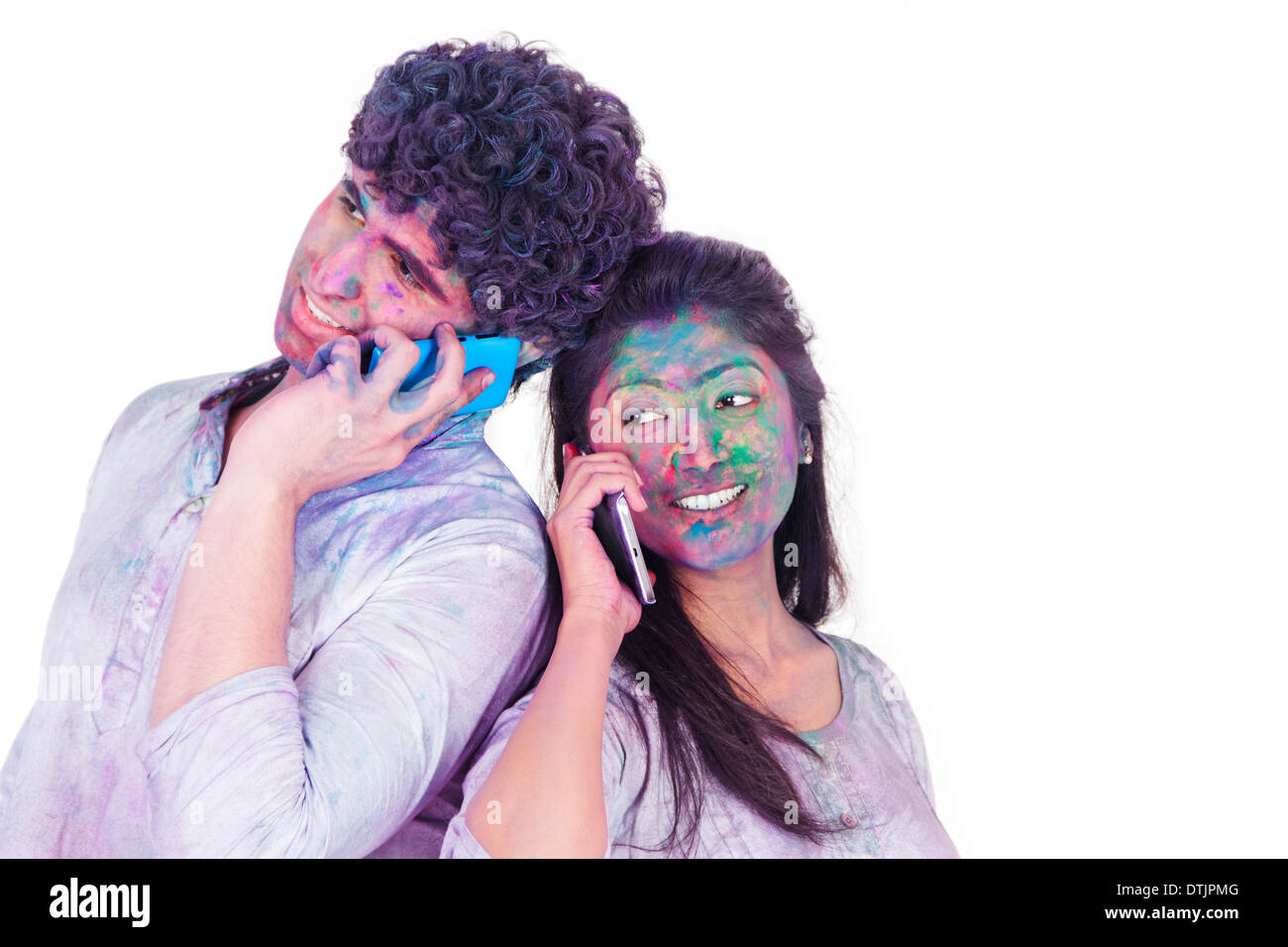 Couple talking on mobile phones on Holi Stock Photo