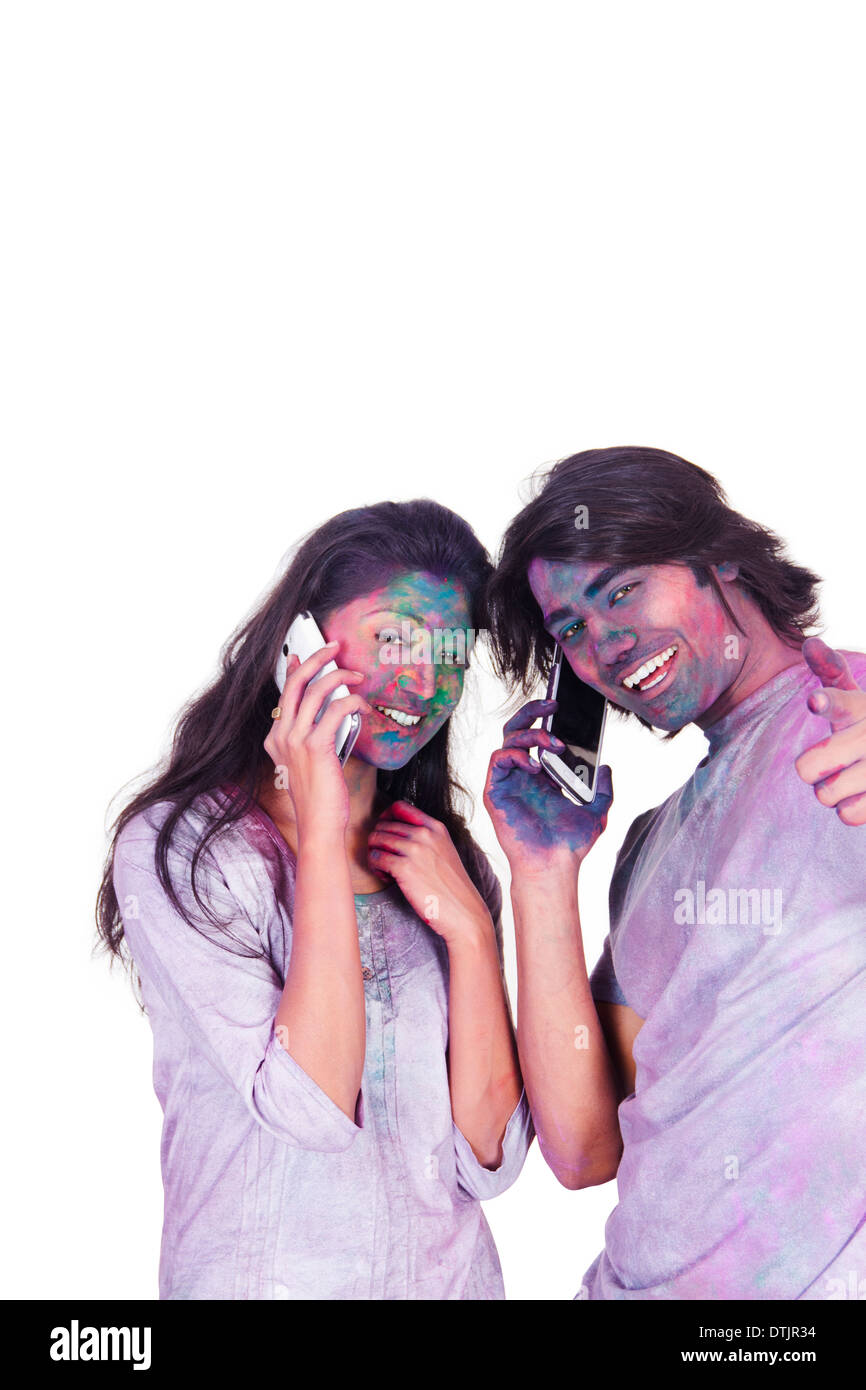 Couple talking on mobile phones on Holi Stock Photo