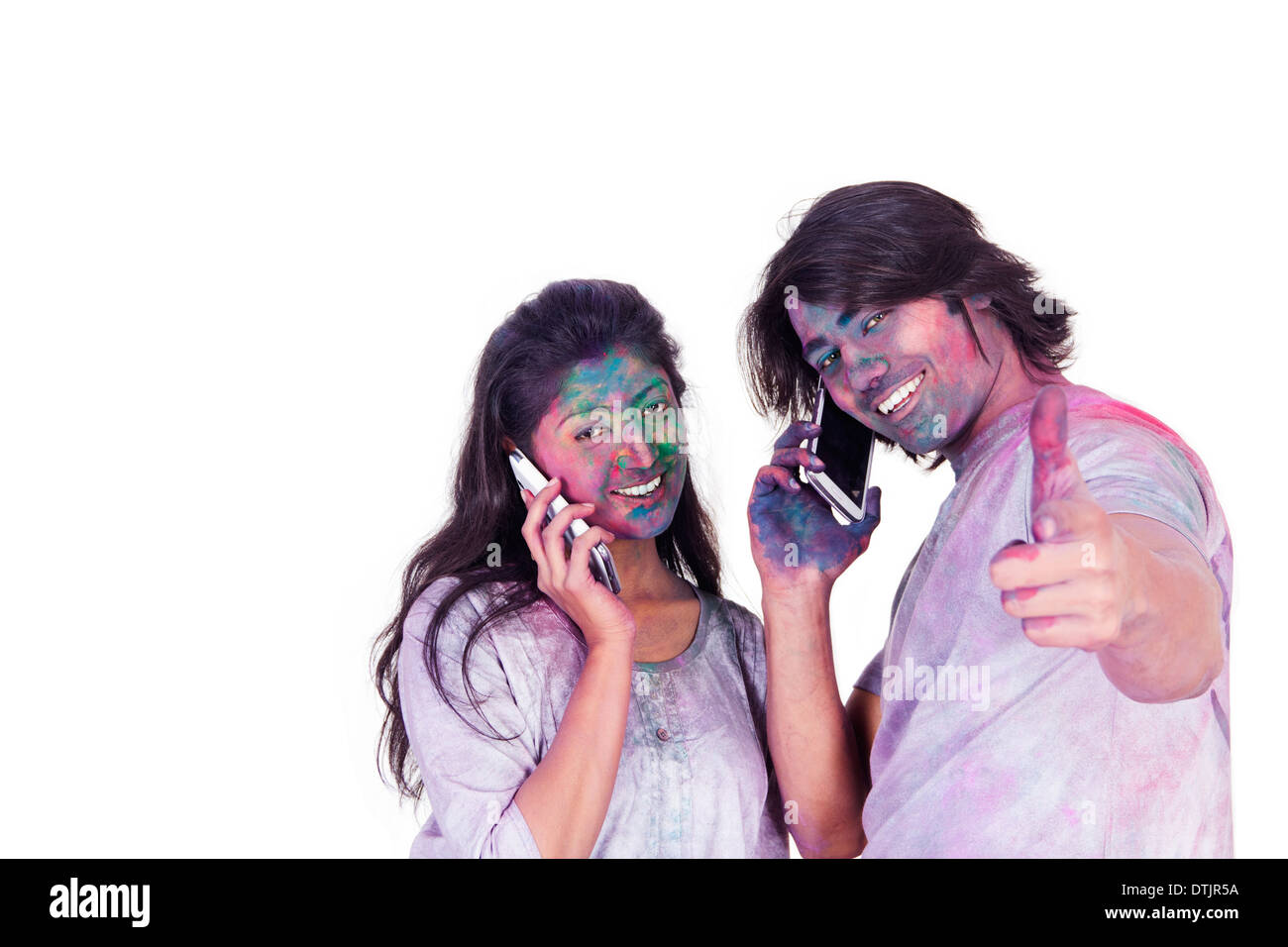 Couple talking on mobile phones on Holi Stock Photo