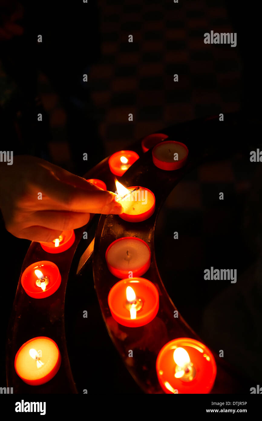 Lighting a votive candle Stock Photo Alamy