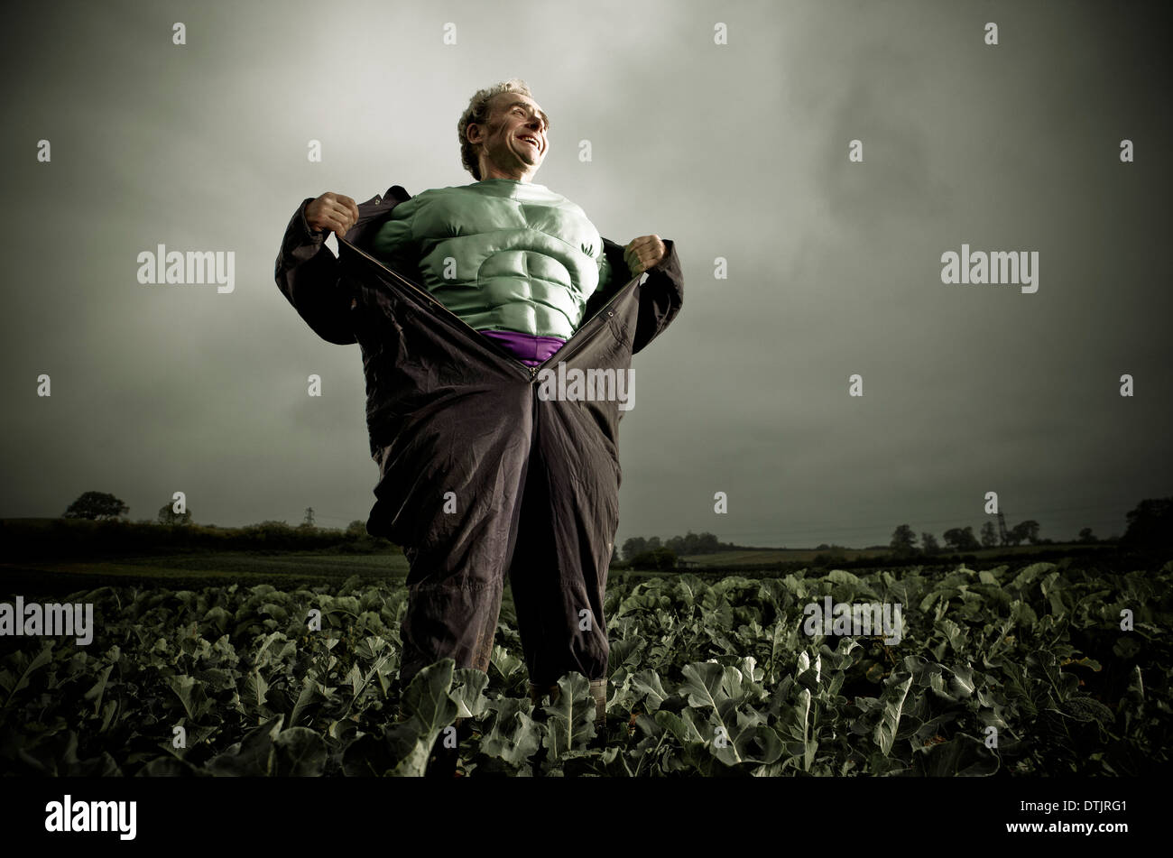 SUPERHERO COSTUME MAN STANDING IN A FIELD Stock Photo