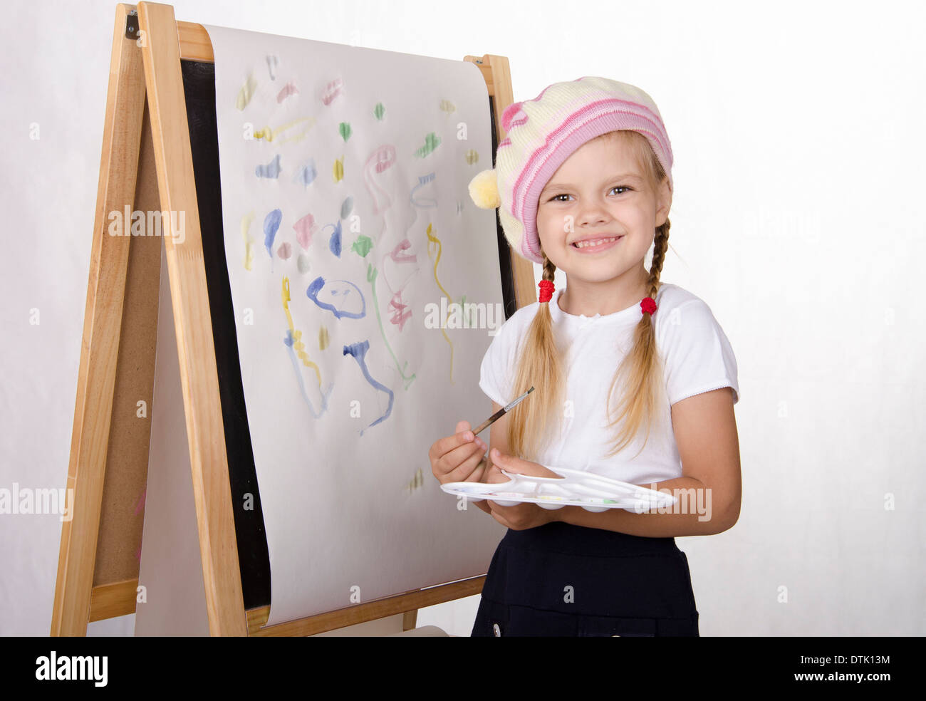 Fouryearold girl draws on the easelpainting. In the arms of children