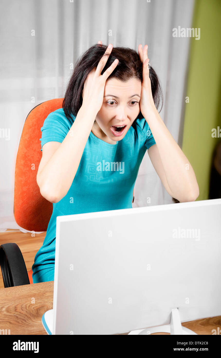 Frightened woman is looking at the laptop screen Stock Photo - Alamy