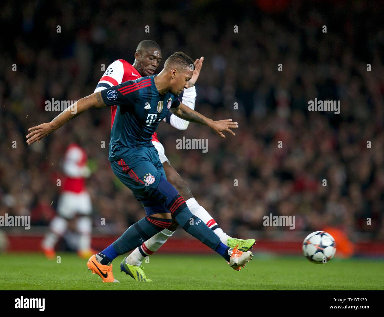 London, UK. 19th Feb, 2014. Yaya Sanogo of Arsenal challenges Philipp Lahm of Bayern Munich during the Champions League game between Arsenal and Bayern Munich from the Emirates Stadium. Credit:  Action Plus Sports/Alamy Live News Stock Photo