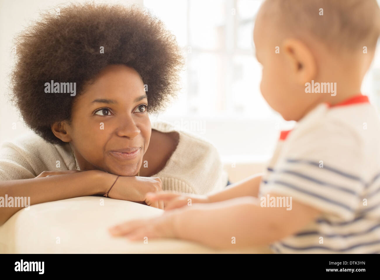 Mother and baby boy playing on sofa Stock Photo