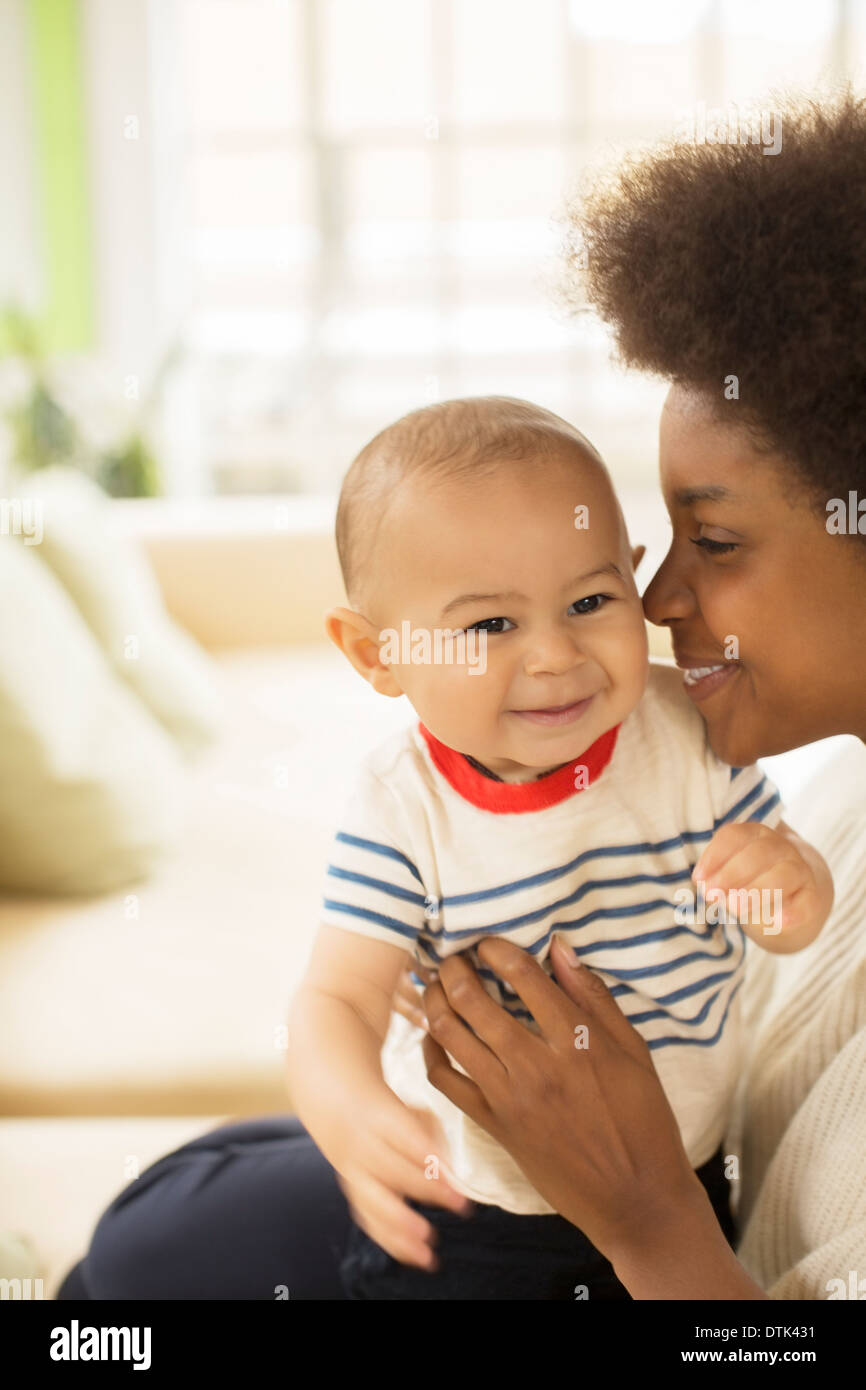 Mother holding baby boy on sofa Stock Photo