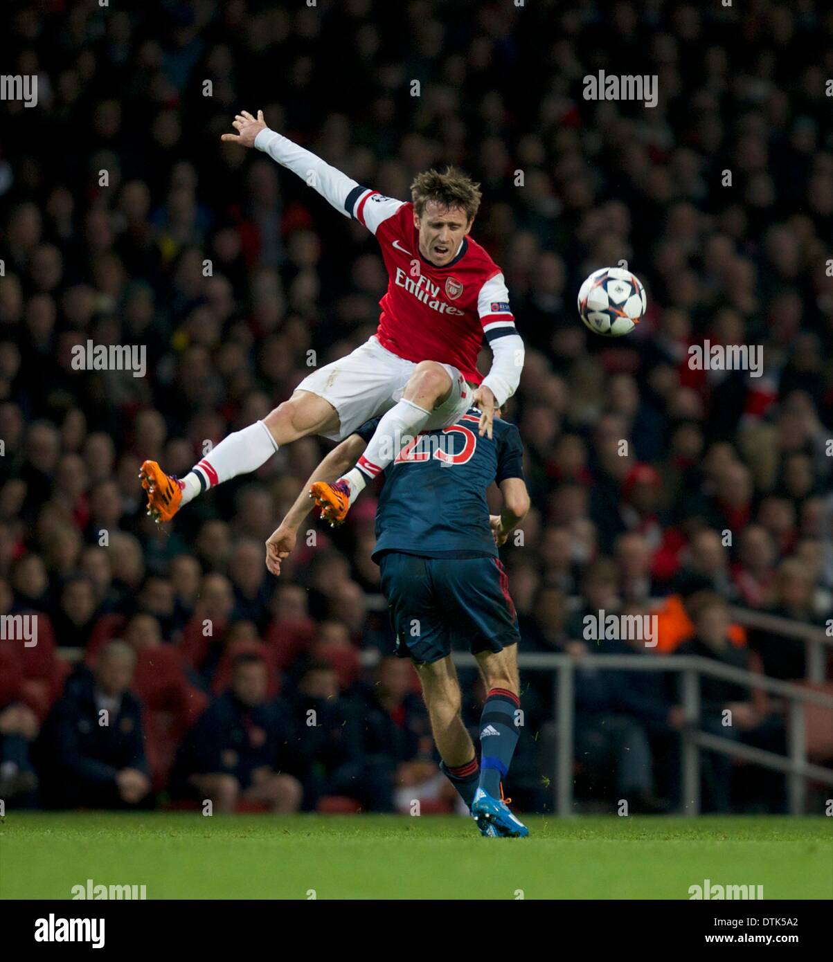 London, UK. 19th Feb, 2014. Nacho Monreal of Arsenal goes for a ride on the back of Thomas M&#xfc;ller of Bayern Munich during the Champions League game between Arsenal and Bayern Munich from the Emirates Stadium. Credit:  Action Plus Sports/Alamy Live News Stock Photo