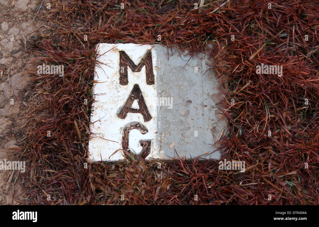White MAG or Mines Advisory Group marker brick showing a safe area at the Plain of Jars in Laos Stock Photo