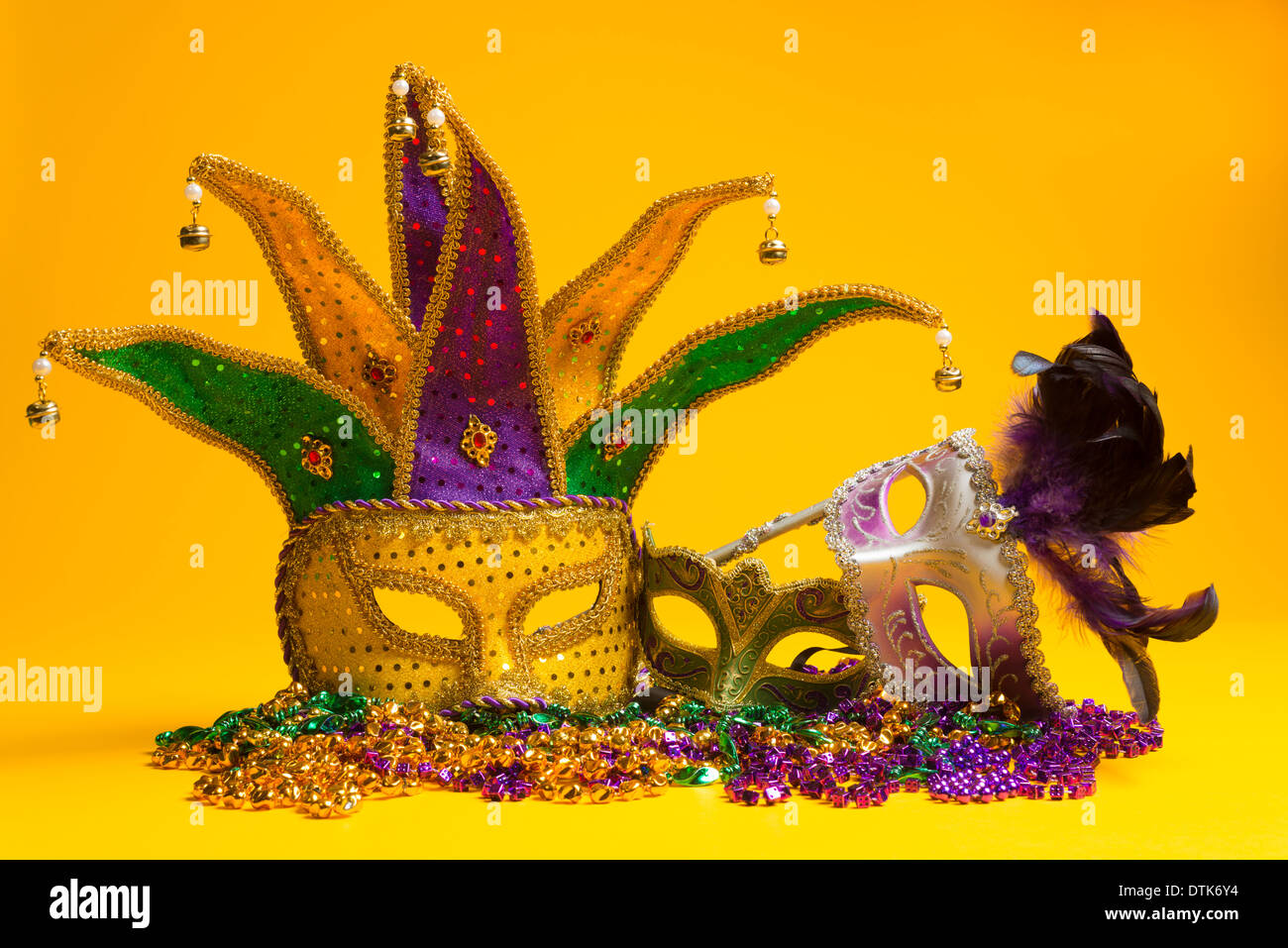 A festive, colorful group of mardi gras or carnivale masks on a yellow background. Venetian masks. Stock Photo