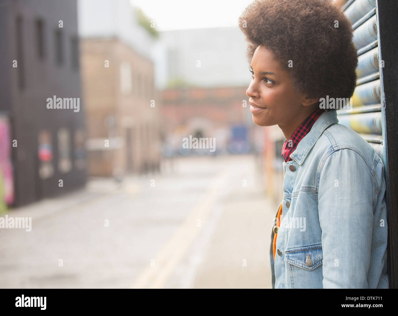 Pensive woman standing on city street Stock Photo