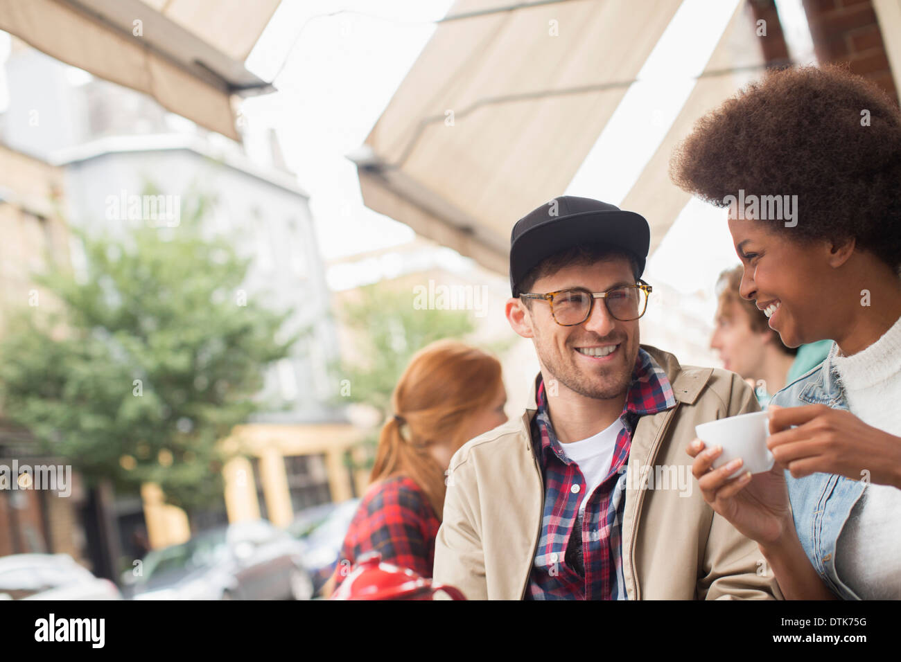 Couple drinking coffee at sidewalk cafe Stock Photo