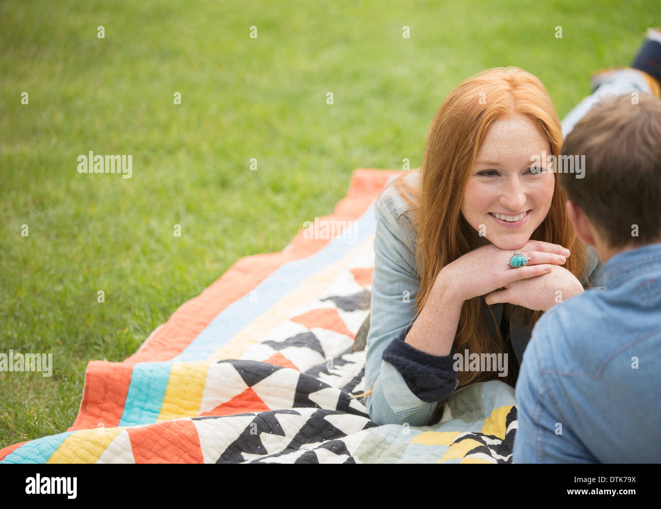 Couple relaxing on blanket in park Stock Photo