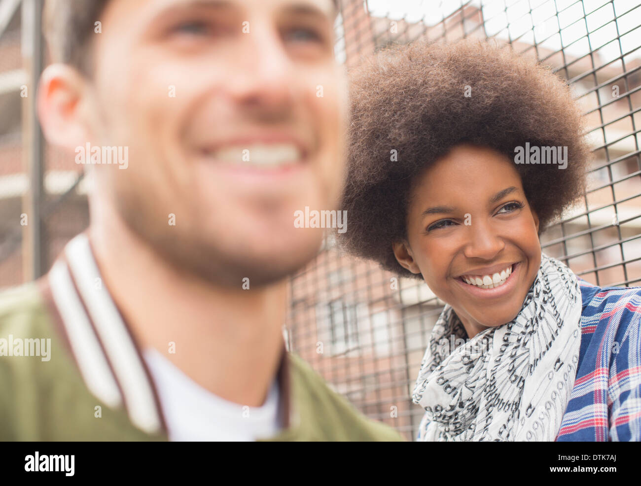 Man and woman smiling near fence Stock Photo