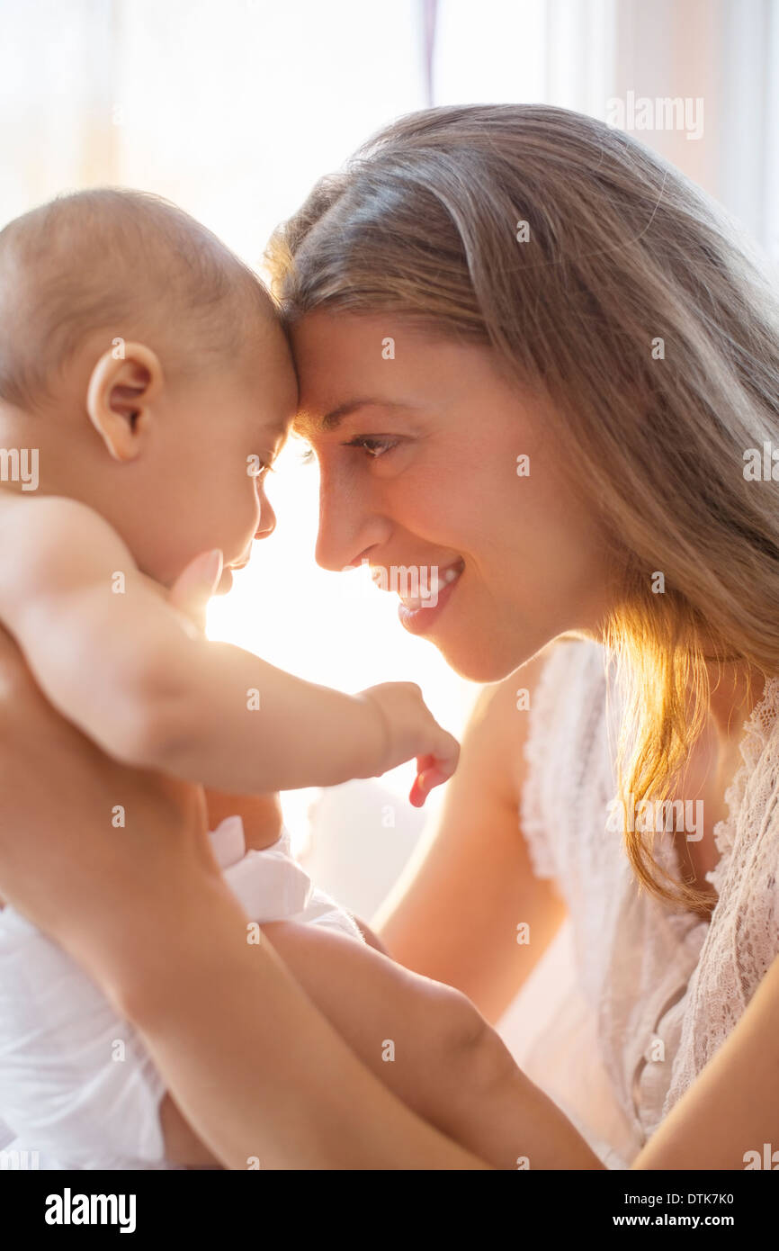 Mother touching foreheads with baby boy Stock Photo