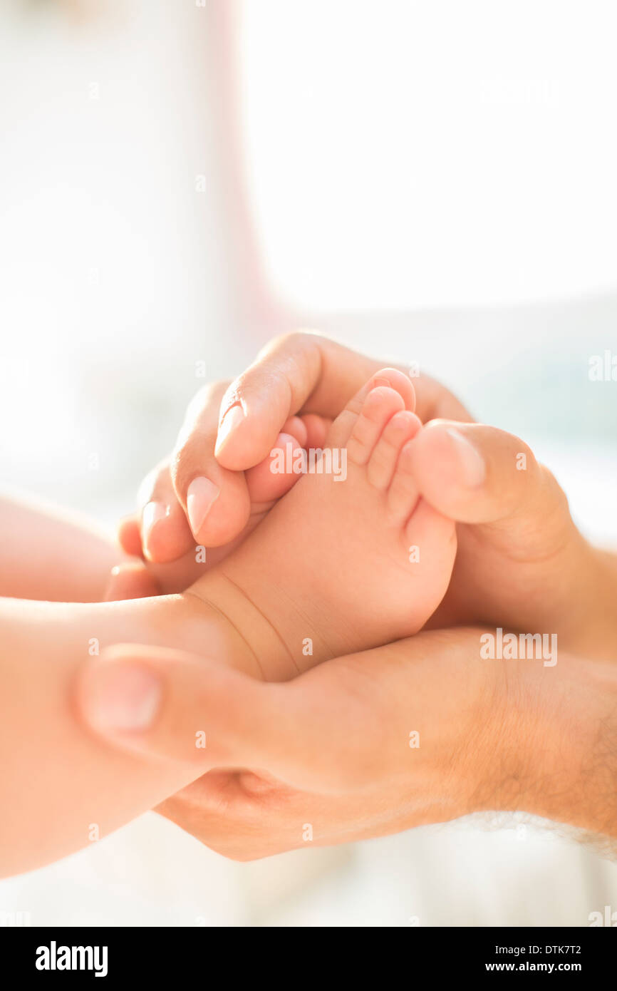 Father cradling baby boy's feet Stock Photo