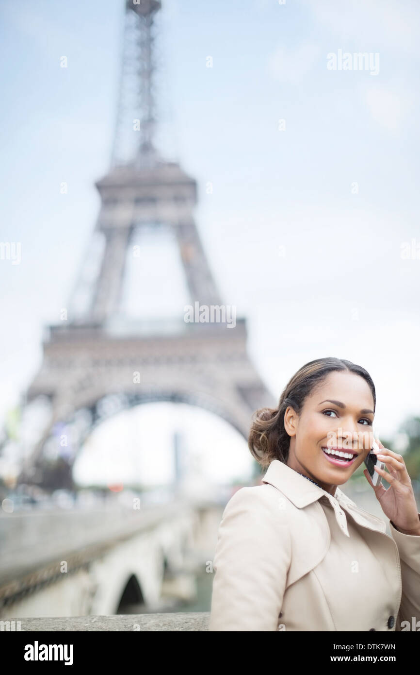Woman talking on cell phone by Eiffel Tower, Paris, France Stock Photo