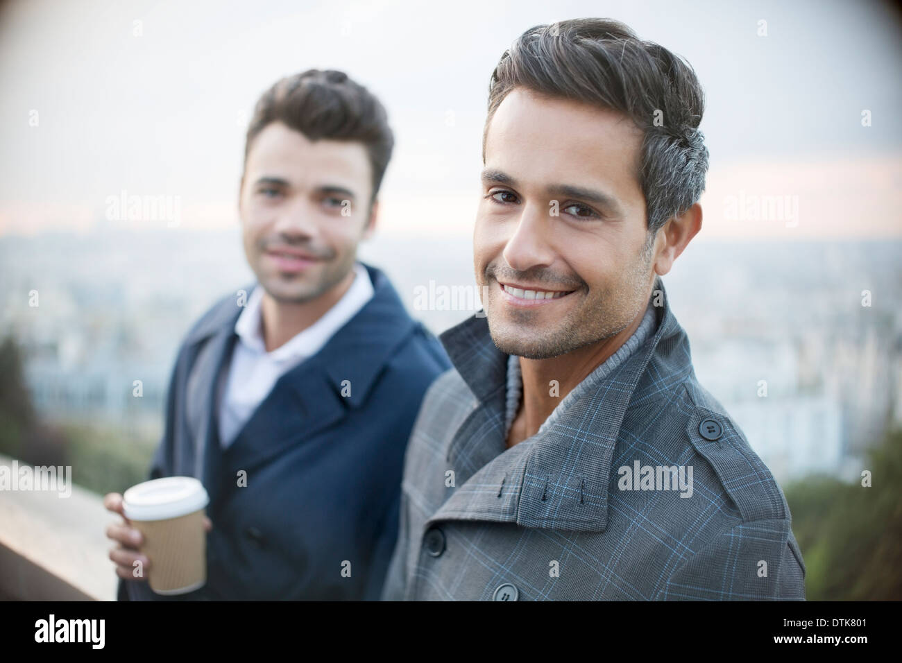 Businessmen smiling with city in background Stock Photo