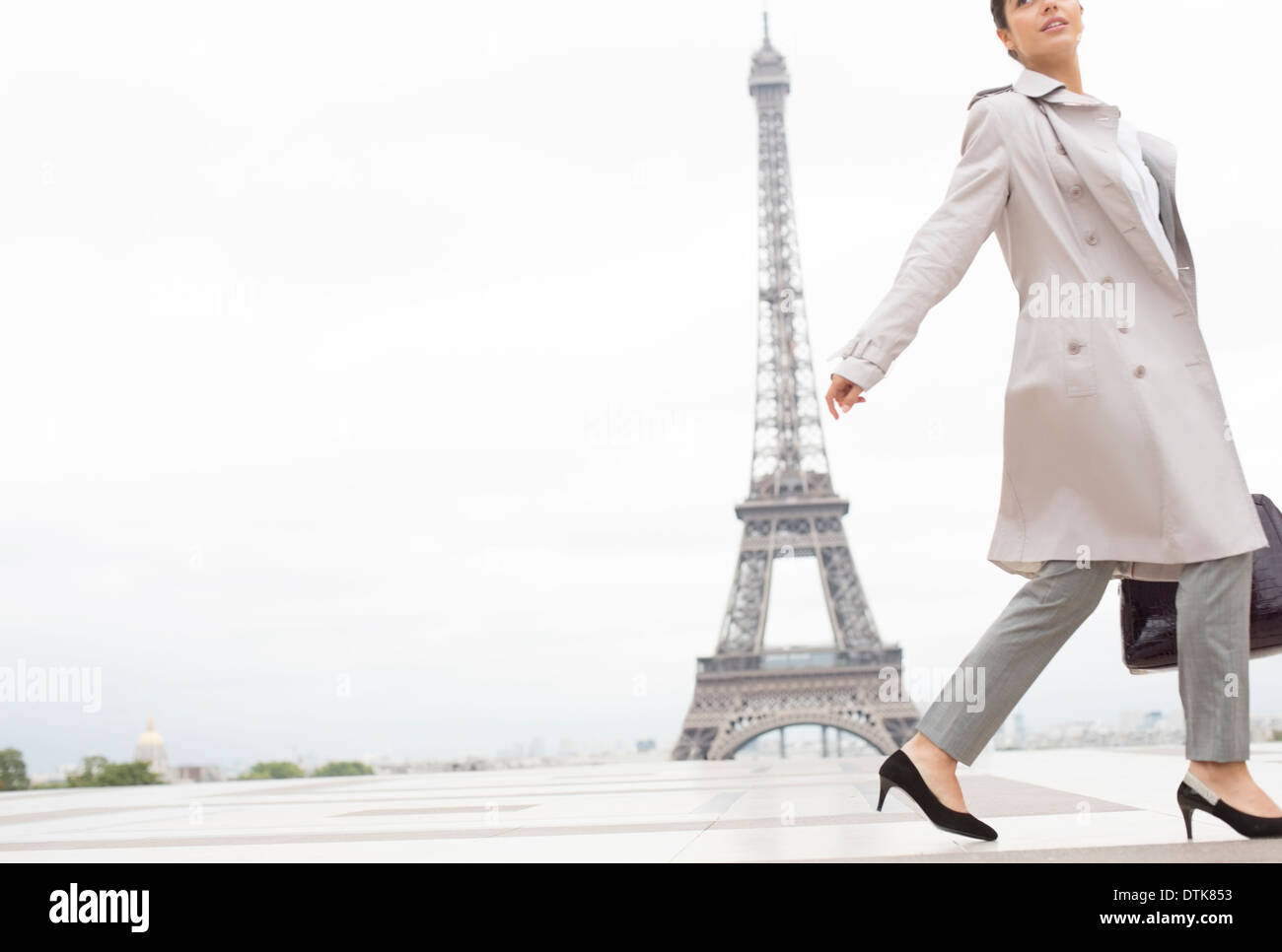 Businesswoman walking past Eiffel Tower, Paris, France Stock Photo