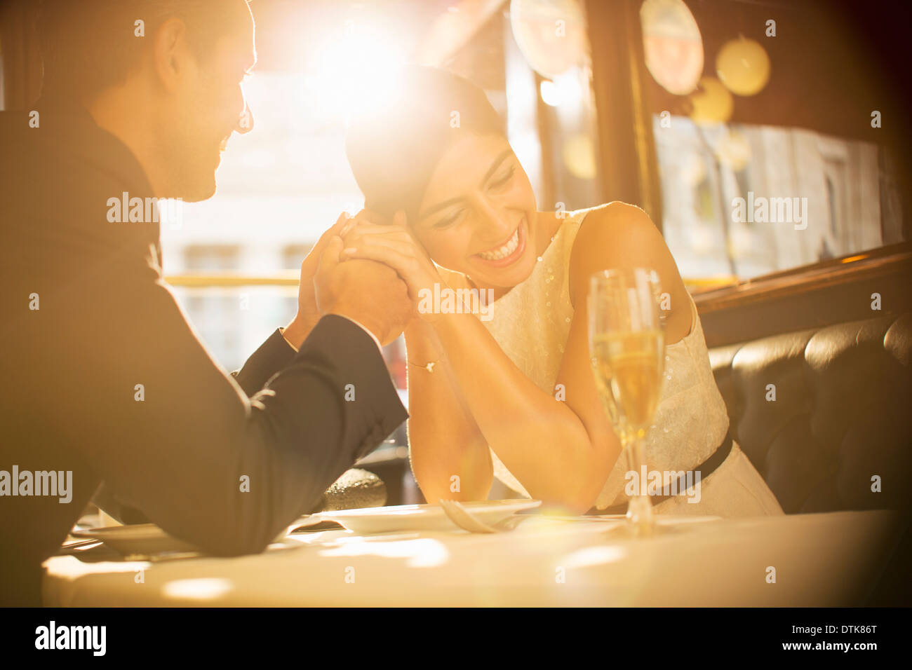 Couple holding hands in restaurant Stock Photo