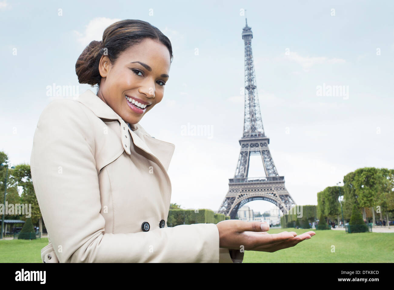 woman posing as if holding the eiffel tower in hands paris france DTK8CD