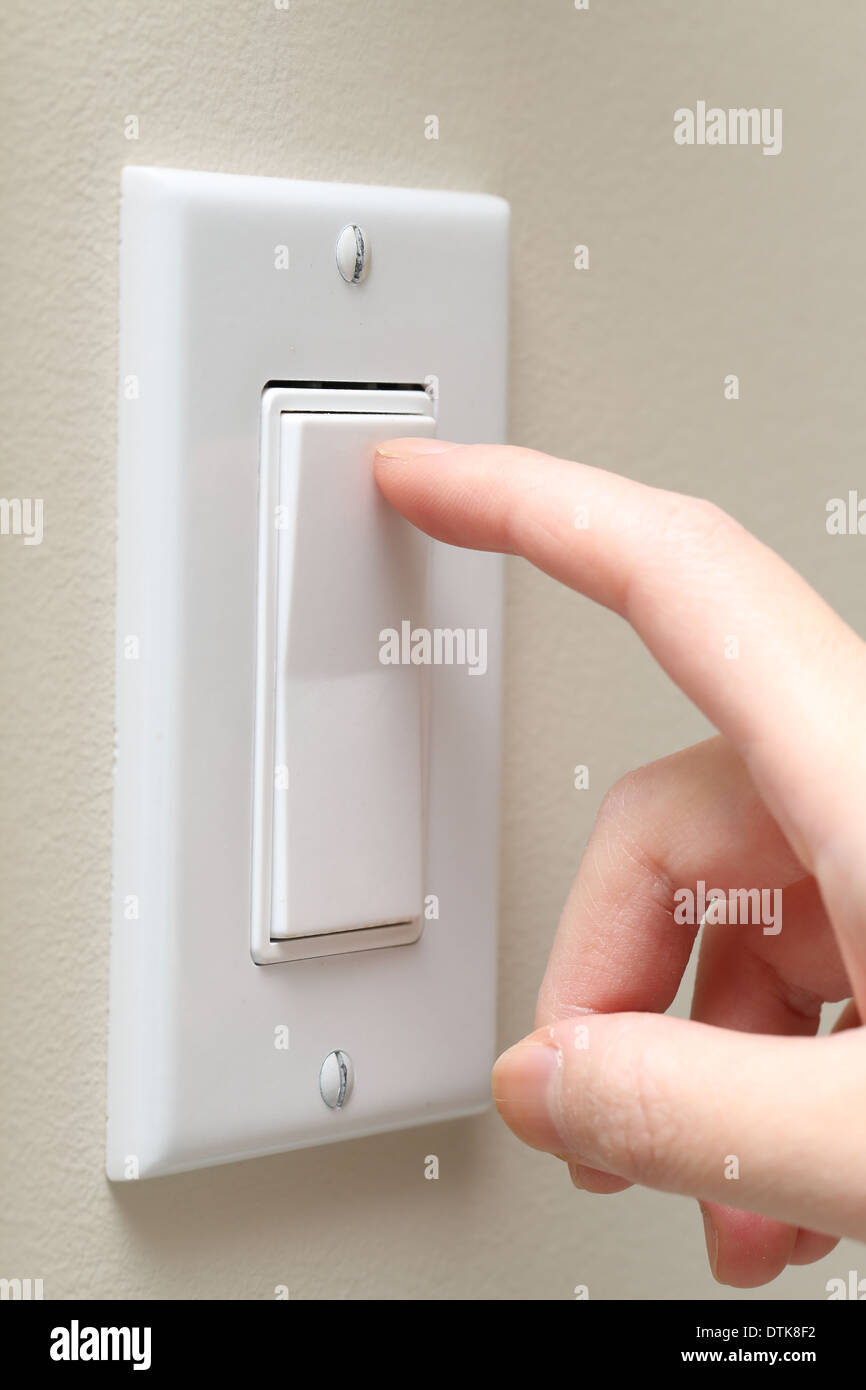 Woman hand turning on the light with a wall switch Stock Photo Alamy