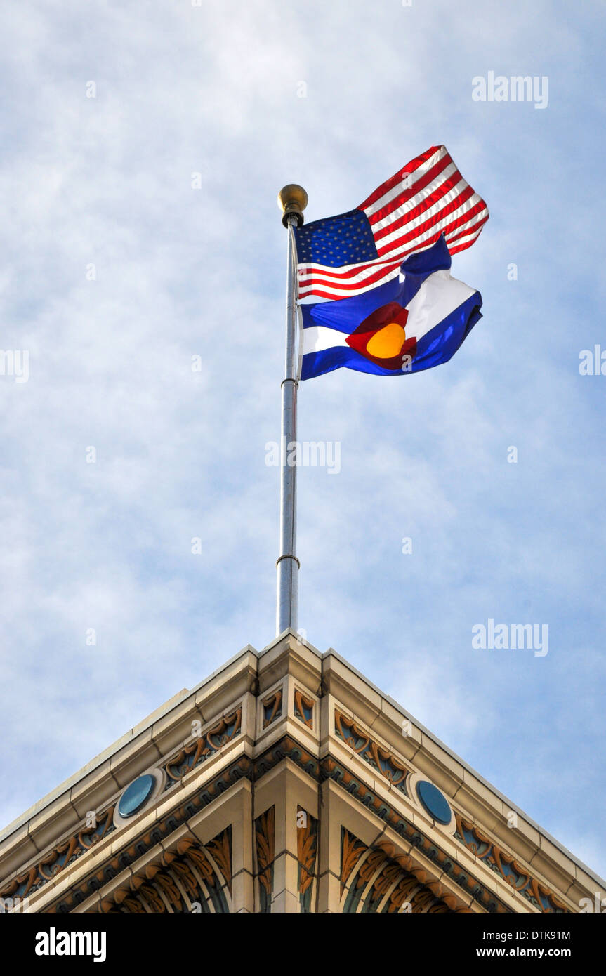 American and Colorado state flag flying atop graphic building Stock
