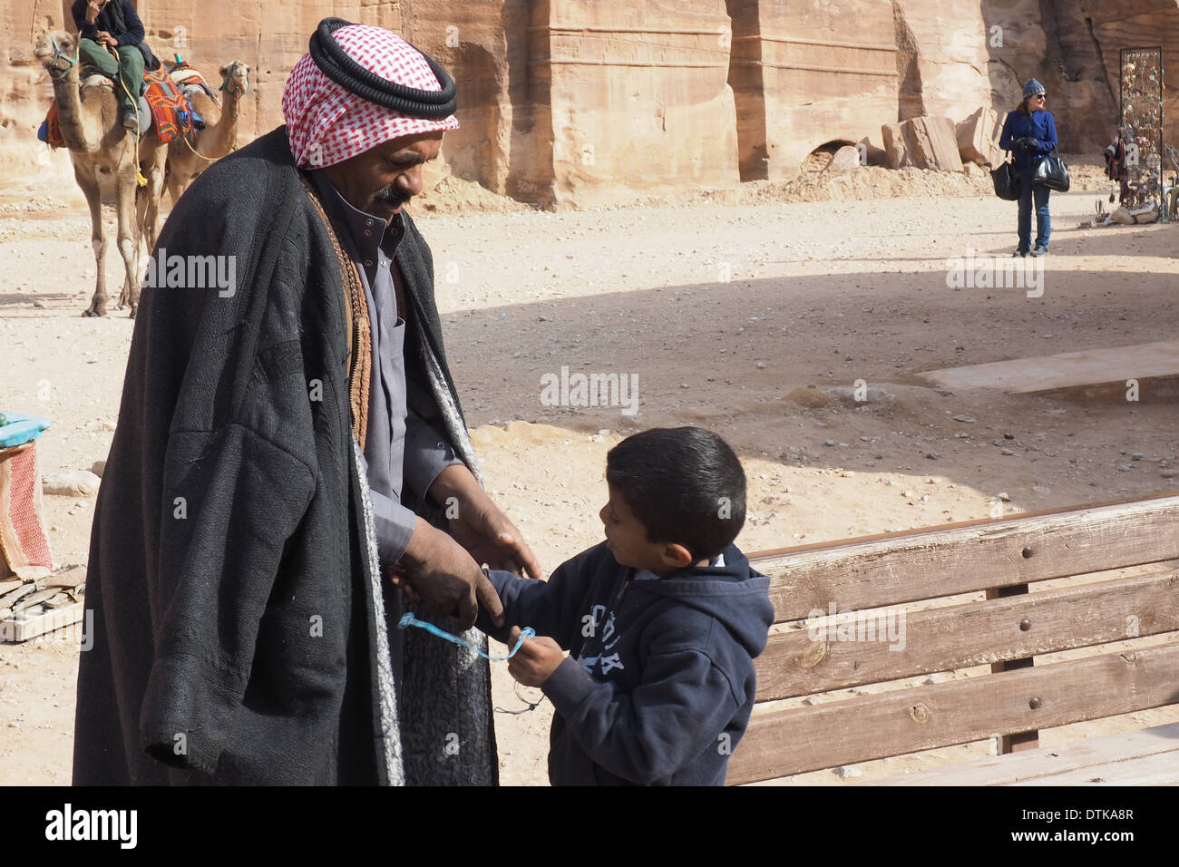Bedouin man shaking hands with a child at Petra a UNESCO World Heritage Site Stock Photo