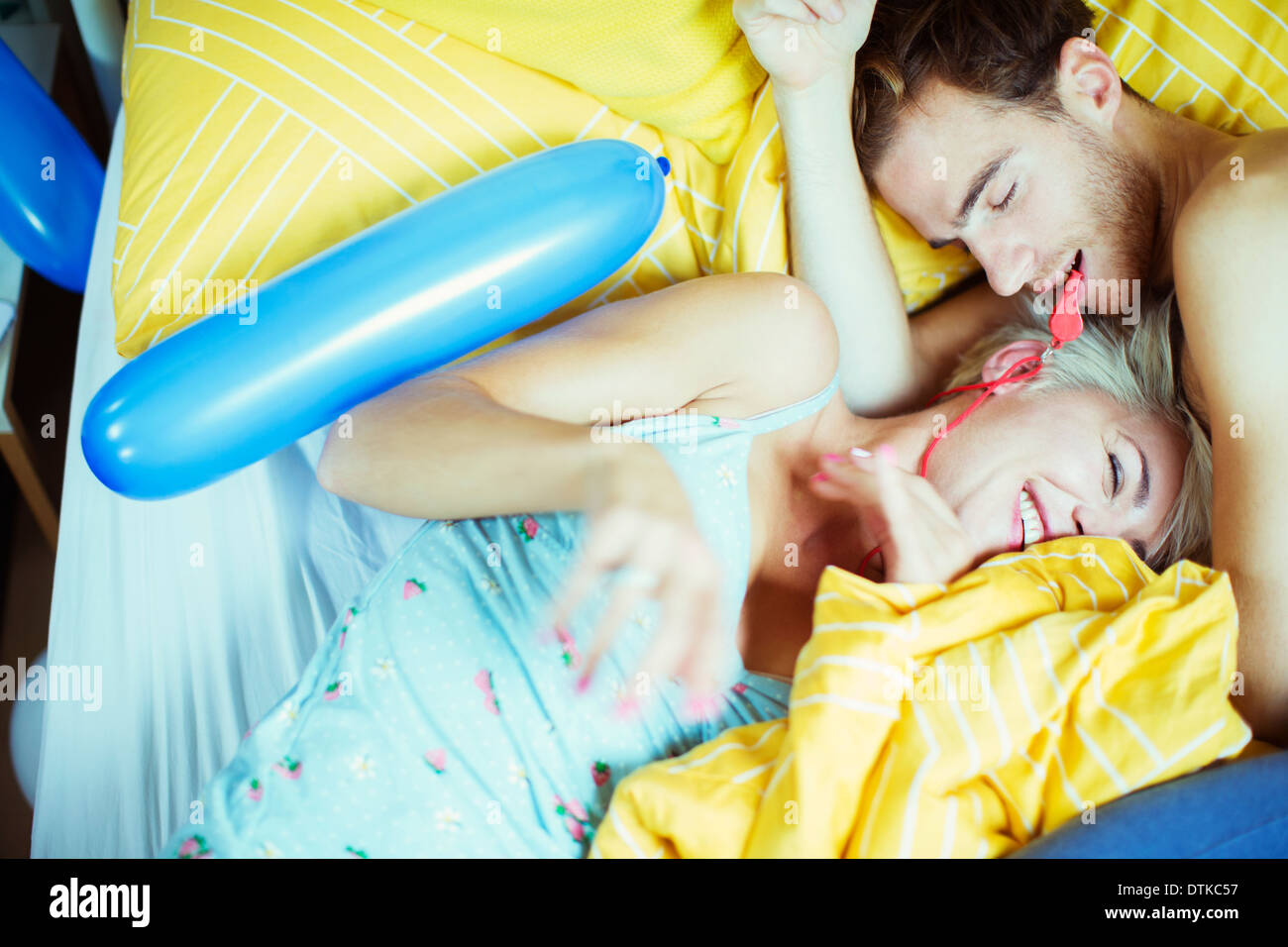 Couple playing in bed with balloons Stock Photo