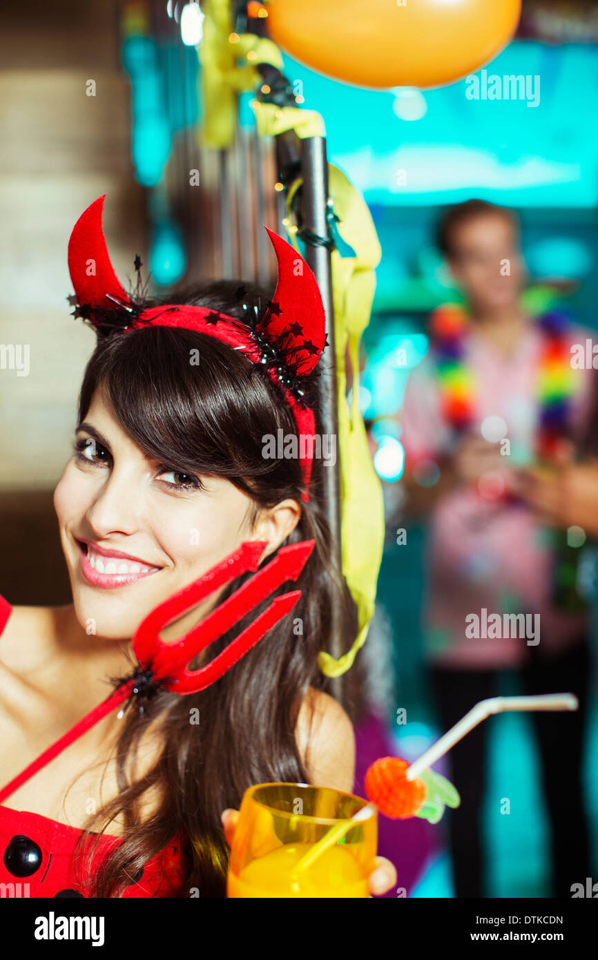 Woman wearing devil costume at party Stock Photo