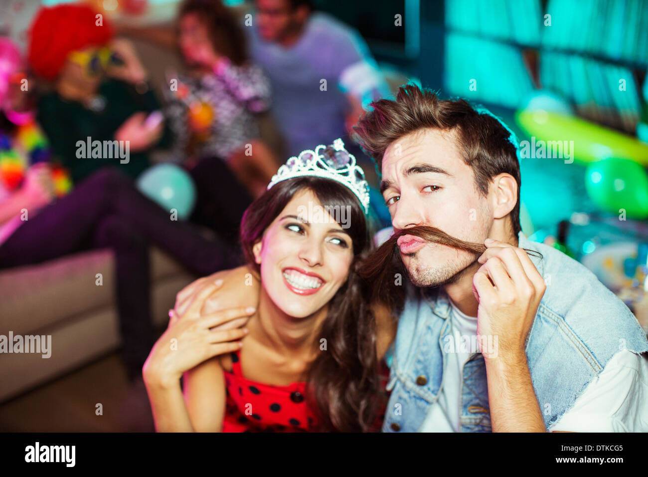 Smiling couple playing together at party Stock Photo