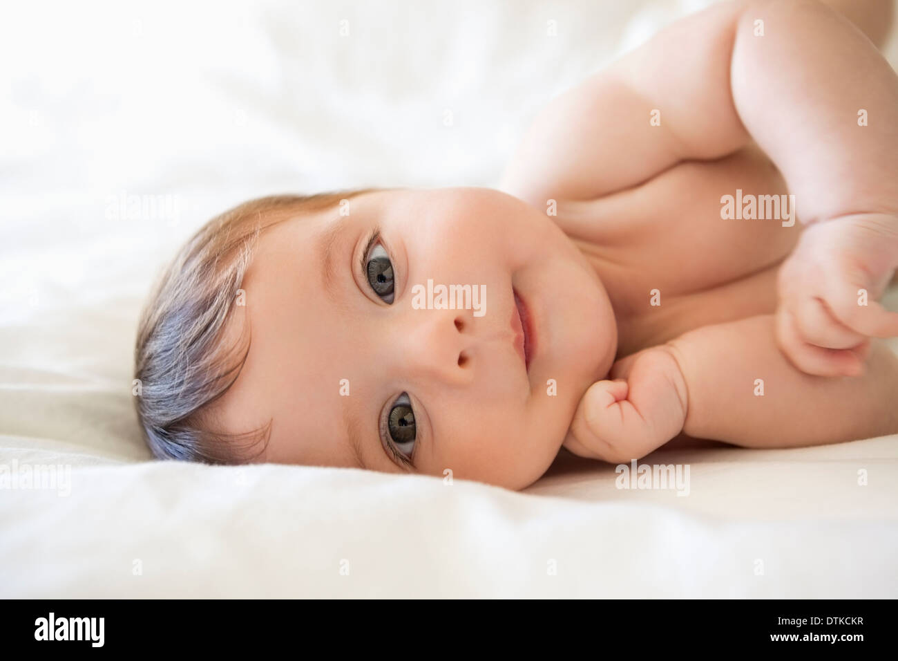 Baby girl laying on bed Stock Photo